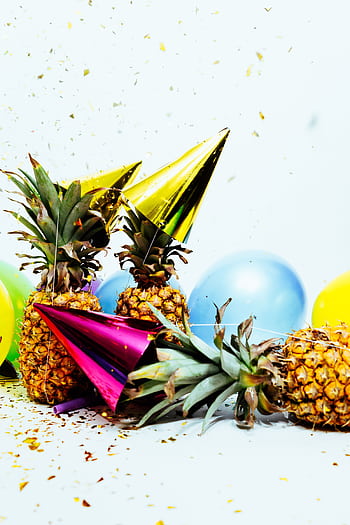 Vibrant party scene with pineapples, balloons, and confetti, perfect for celebration themes. HD phone wallpaper