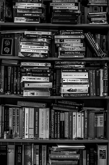 A black and white of a packed bookshelf with various books in a library setting. HD phone wallpaper