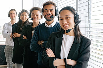 A diverse group of smiling call center agents in an office setting. HD wallpaper