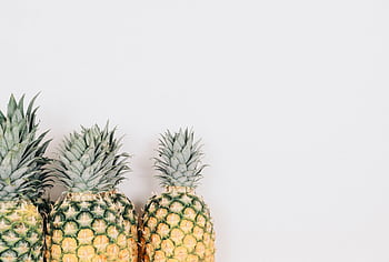 Three pineapples against a white background, ideal for tropical themes. HD wallpaper