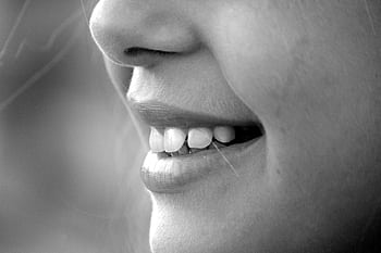 A monochrome close-up of a smiling face showcasing teeth and lips. HD wallpaper