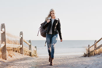 Stylish woman in leather jacket walking by the ocean in Ocean City, NJ. HD wallpaper