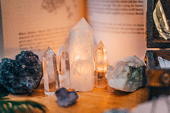 Close-up of various healing crystals on a wooden table with warm lighting HD wallpaper