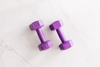 Overhead shot of two purple dumbbells on a white marble surface. HD wallpaper