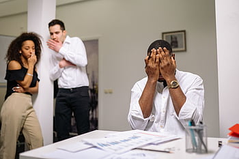 Diverse coworkers in tense office conflict scene, highlighting workplace issues. HD wallpaper