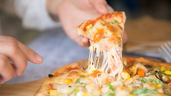 Appetizing close-up of a cheesy pizza slice with toppings, being pulled from a freshly baked pie. HD wallpaper