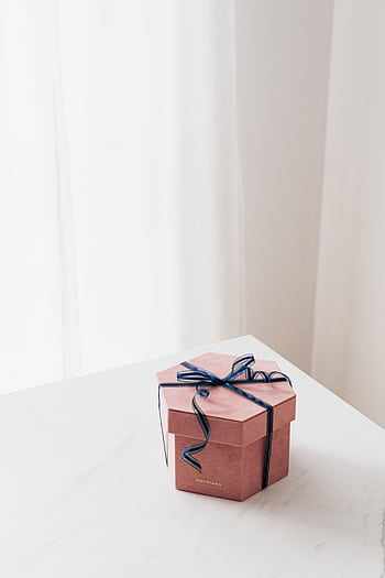 Stylish pink gift box with black ribbon on a white background, perfect for special occasions. HD phone wallpaper