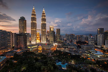 Stunning Kuala Lumpur skyline featuring the illuminated Petronas Towers at twilight. HD wallpaper