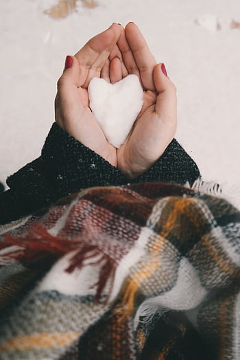 Close-up of hands holding a heart-shaped snow piece, wrapped in winter clothing. HD phone wallpaper
