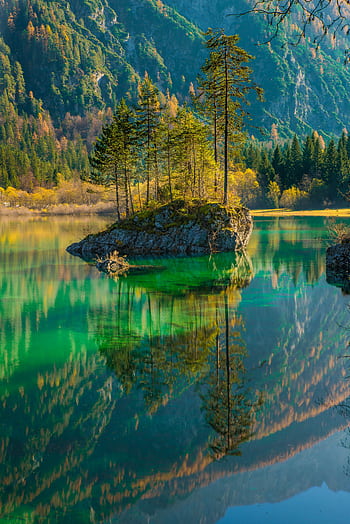 Stunning fall scenery of a tranquil mountain lake reflecting surrounding trees and mountains. HD phone wallpaper