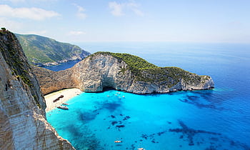 Stunning aerial view of Navagio Beach in Zakynthos, Greece, featuring turquoise water and a sunken ship. HD wallpaper