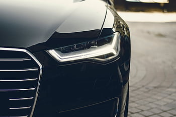 A sleek, modern luxury car showcasing its chrome detailing and LED headlights on a city street. HD wallpaper