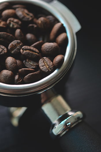 Aromatic coffee beans resting in a metal portafilter, ready for brewing. HD phone wallpaper