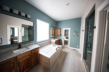 Spacious modern bathroom featuring a standing bathtub, wooden cabinets, and granite countertops. HD wallpaper