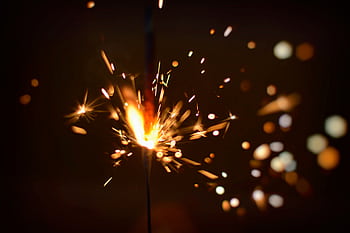 Capture the energy of fireworks with this close-up of a sparking firecracker, bursting with light. HD wallpaper