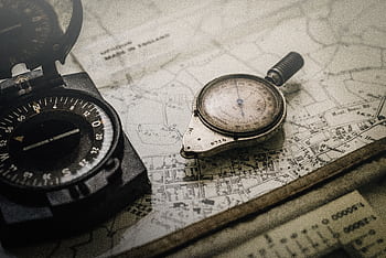 A vintage compass and navigation instrument on an old map, showcasing precision tools for exploration. HD wallpaper