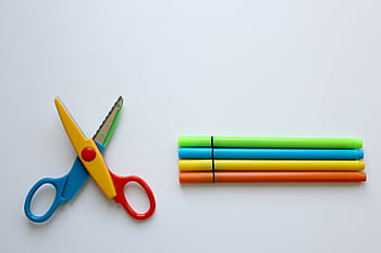 Bright stationery set on a white background with colorful scissors and markers. HD wallpaper
