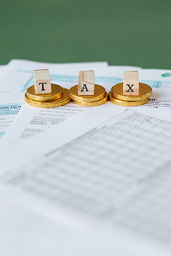 Staged of gold coins with tax letter tiles on documents. HD phone wallpaper