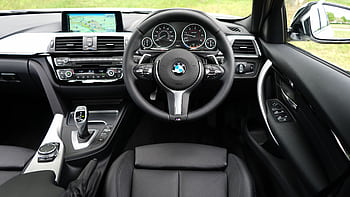Explore the luxurious interior of a BMW car featuring a modern dashboard and navigation system. HD wallpaper