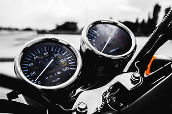 Detailed shot of a motorcycle's speedometer and tachometer in focus, showcasing precision engineering. HD wallpaper