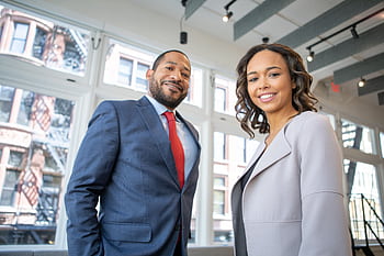 Business professionals smiling in a modern Detroit office setting. HD wallpaper