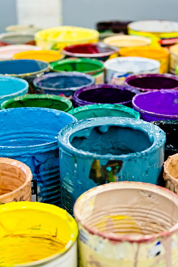 A vivid assortment of open paint cans displaying a spectrum of colors, ideal for artistic and design projects. HD phone wallpaper