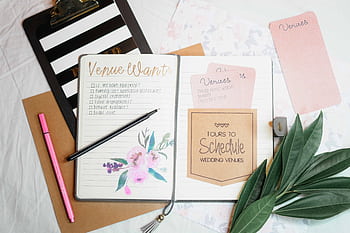 Flat lay of wedding planning materials including a journal, leaves, and stationery. HD wallpaper