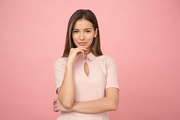 Portrait of a young woman posing elegantly in a studio with a pink background. HD wallpaper