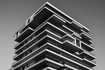 A striking black and white of a modern high-rise building with unique geometric designs. HD wallpaper