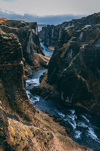 Breathtaking view of the Fjadrargljufur Canyon with a flowing river and steep rocky cliffs. HD phone wallpaper