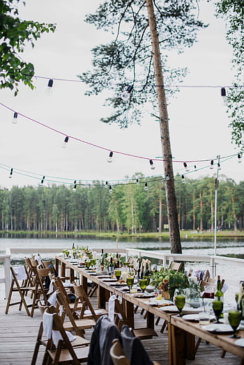 A tranquil outdoor dinner setting by a lake, perfect for a rustic wedding or celebration. HD phone wallpaper