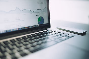 A laptop showing an analytics dashboard with charts and graphs, symbolizing modern data analysis tools. HD wallpaper