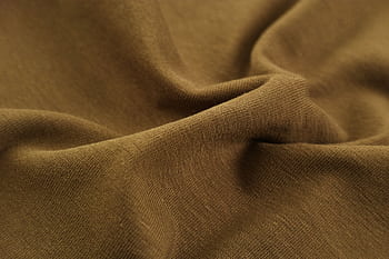 Detailed close-up view of brown fabric with visible folds, creases, and texture. HD wallpaper