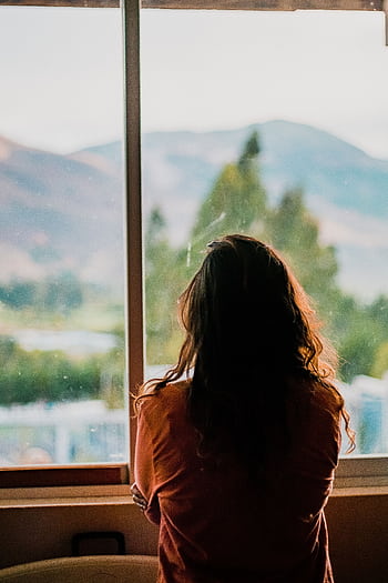 Silhouette of a woman looking out a window at a scenic mountain view in Cajamarca, Peru. HD phone wallpaper