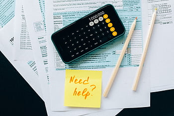 Top view of financial papers with a calculator, pencils, and a note saying 'Need help?' indicating tax or accounting assistance. HD wallpaper