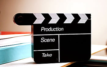 Close-up of a film clapperboard on a desk, ideal for media and production themes. HD wallpaper