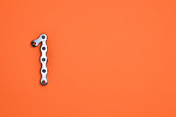 Metal chain forming the number one on an orange background, ideal for design concepts. HD wallpaper