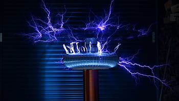 A Tesla coil producing powerful electric arcs in a dark setting. HD wallpaper