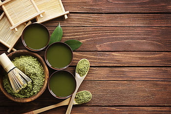 Top view of traditional matcha tea setup with utensils on a wooden table, showcasing a blend of culture and flavor. HD wallpaper