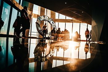 Silhouette of people enjoying sunset views from a modern skyscraper in New York City. HD wallpaper