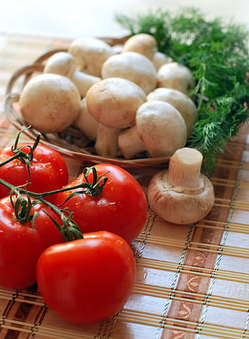 Close-up of fresh tomatoes and mushrooms on a rustic wooden mat, ideal for healthy cooking. HD phone wallpaper