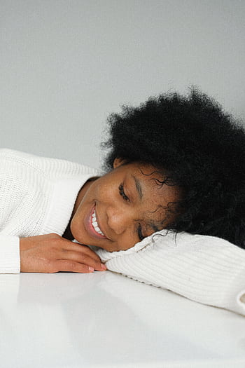 A serene portrait of an African American woman peacefully daydreaming indoors. HD phone wallpaper