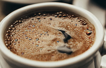 A close-up showcasing freshly brewed coffee in a white cup with visible bubbles. HD wallpaper