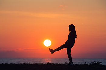Girl kicking at the sun by the beach at sunset, coast, kick, golden hour, girl, gold, dark, beach, woman, shore, waves, ball, clouds, sky, sun, water, ocean HD wallpaper