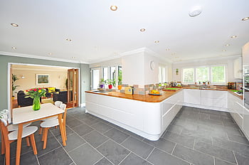 A spacious modern kitchen with elegant interiors featuring a dining table and luxurious design. HD wallpaper