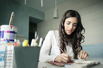 Young woman artist focused on painting at her workspace. HD wallpaper