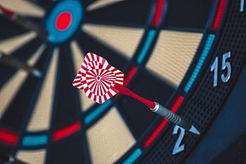 A dart striking the bullseye on a dartboard, showcasing precision and accuracy. HD wallpaper