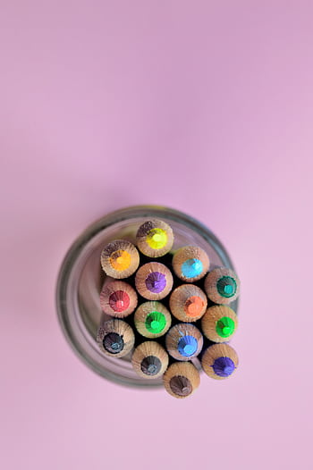 Colorful pencils in a glass jar from above on a pastel backdrop. Perfect for art and educational themes. HD phone wallpaper