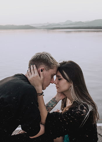 Young couple embracing by the waterside in Rio de Janeiro, capturing a serene and romantic moment. HD phone wallpaper