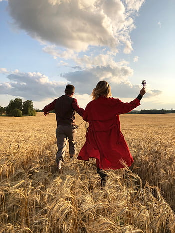 A couple joyfully running through a que wheat field in the countryside during sunset. HD phone wallpaper